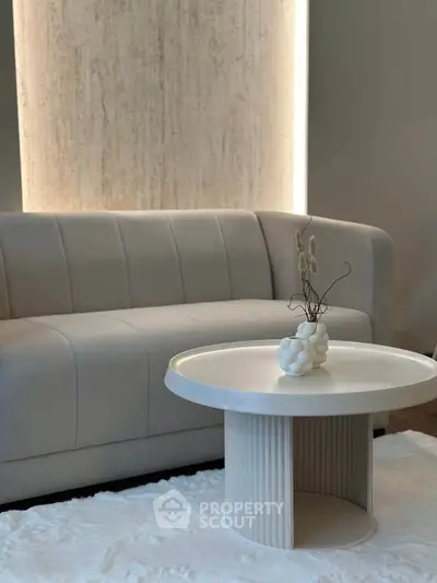 Elegant modern living room with stylish sofa and chic round coffee table on plush rug.