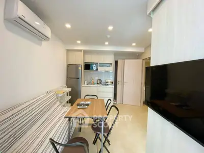 Modern apartment interior with open kitchen and dining area, featuring sleek appliances and contemporary design.