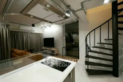 Modern open-plan living room with spiral staircase and sleek kitchen design.