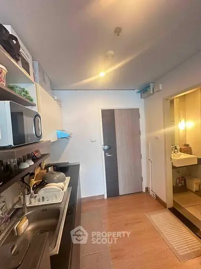 Modern kitchen with sleek appliances and cozy dining area in stylish apartment.