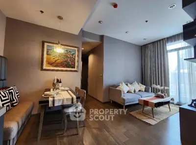 Modern living room with elegant dining area and cozy seating, featuring stylish decor and natural light.