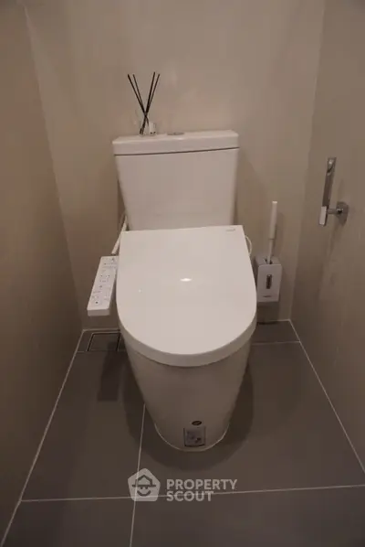 Modern bathroom with sleek toilet and neutral tiles