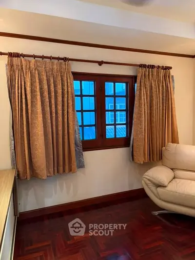 Cozy living room with elegant curtains and stylish leather sofa, perfect for relaxation.