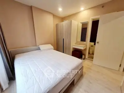 Cozy bedroom with modern furnishings and ensuite bathroom in a stylish apartment.
