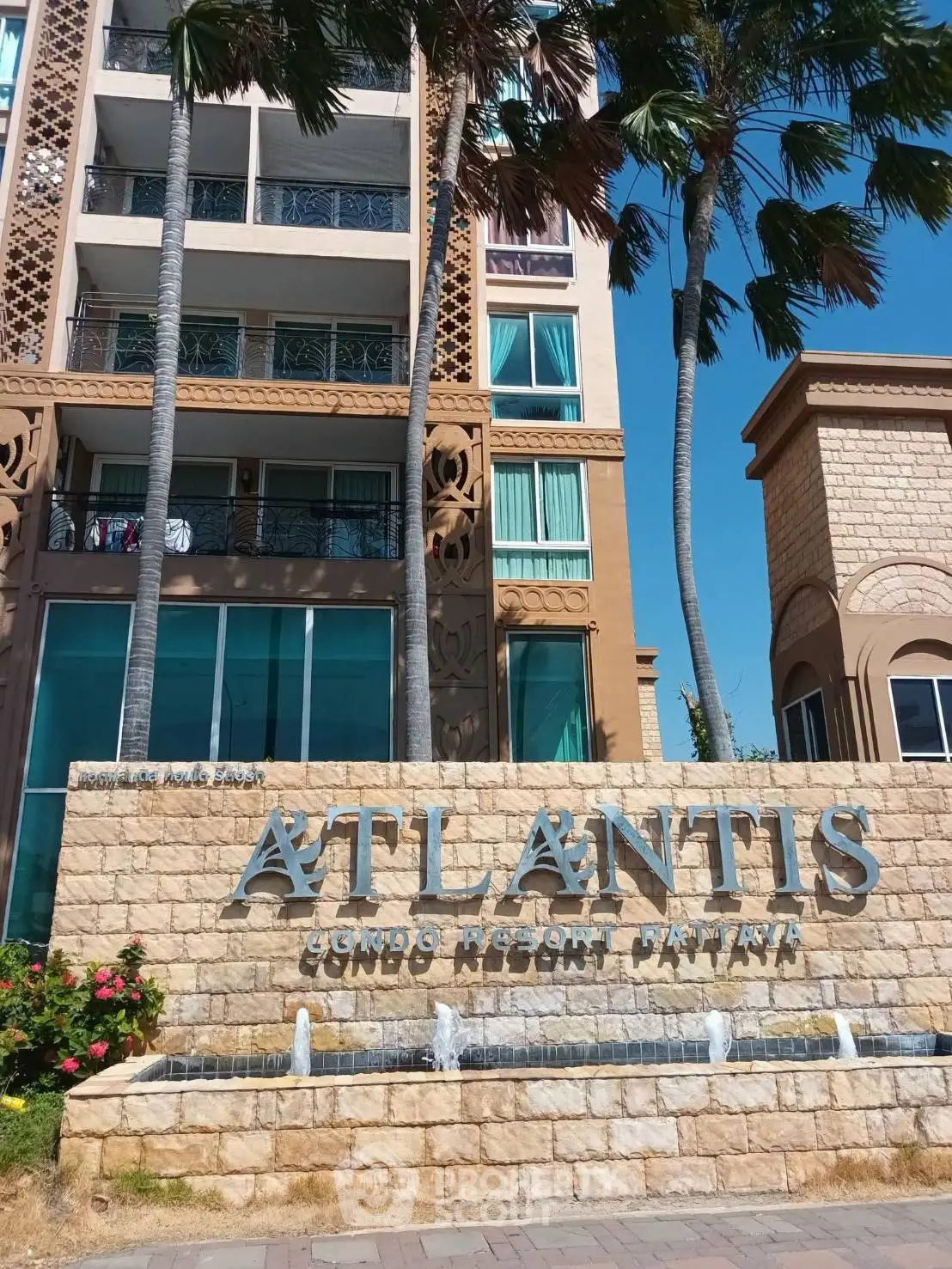 Luxurious Atlantis Condo Resort exterior with palm trees and elegant architecture in Pattaya.
