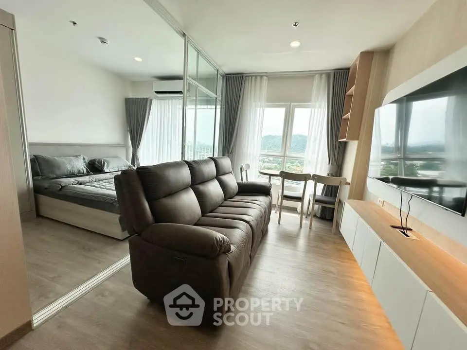 Modern living room with large window view and cozy seating in stylish apartment