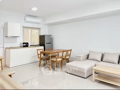 Modern open-plan living room with sleek kitchen and cozy dining area