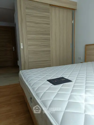 Modern bedroom with wooden sliding closet and comfortable mattress
