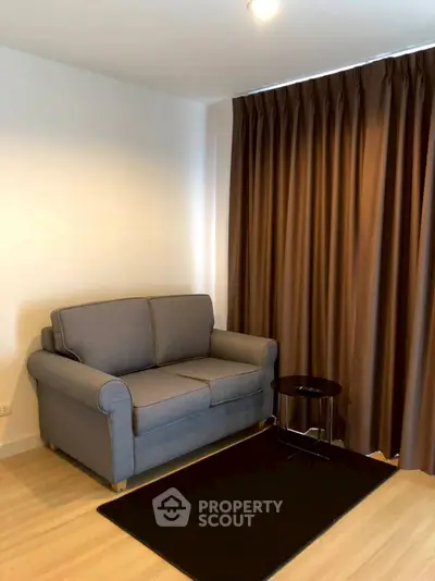 Cozy living room with grey sofa and brown curtains, perfect for relaxation.