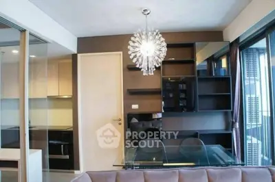 Modern living room with stylish chandelier and glass dining table