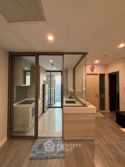 Modern kitchen with glass partition and sleek appliances in a stylish apartment