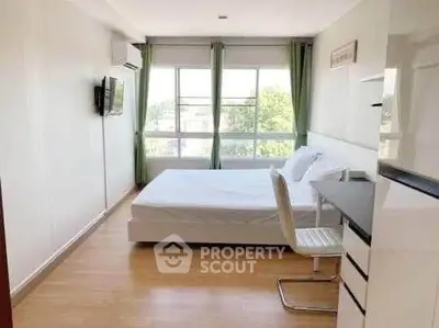 Bright bedroom with large windows and modern furnishings, ideal for comfortable living.