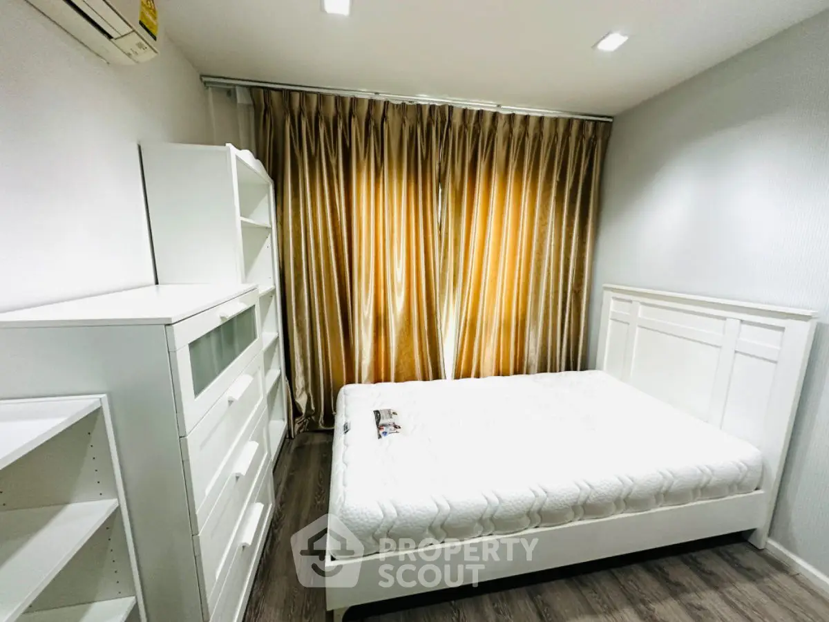 Modern bedroom with white furniture and elegant curtains, perfect for a cozy living space.