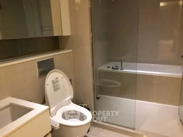 Modern bathroom with sleek fixtures and glass-enclosed bathtub