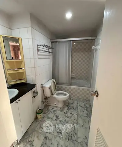 Modern bathroom with marble flooring and bathtub in stylish apartment.