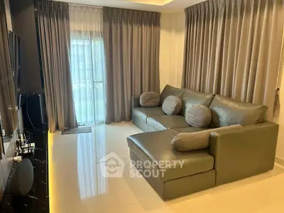 Modern living room with sleek leather sofa and floor-to-ceiling curtains