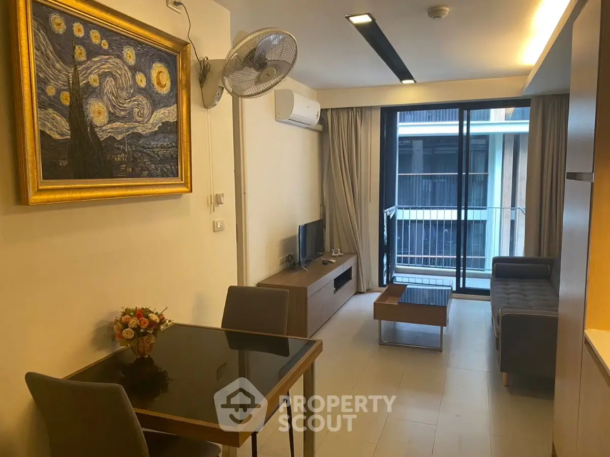 Modern living room with stylish decor and balcony view in urban apartment.