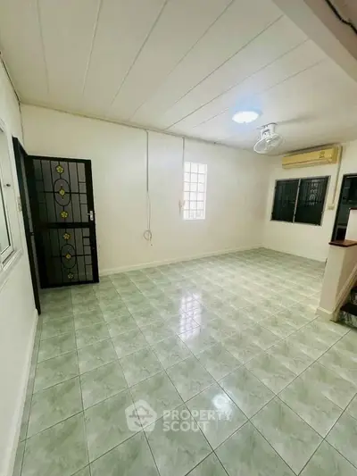 Spacious living room with tiled floor and air conditioning in a modern home.