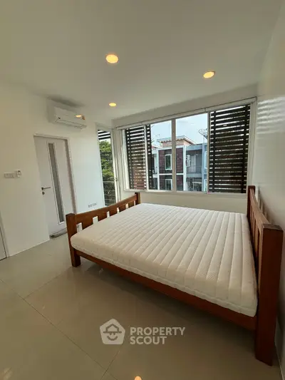 Spacious bedroom with large windows and modern design in a luxury apartment.