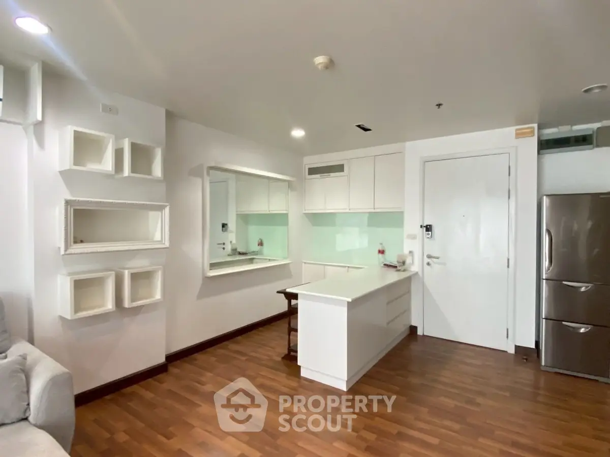 Modern kitchen with sleek design and hardwood floors in a stylish apartment.