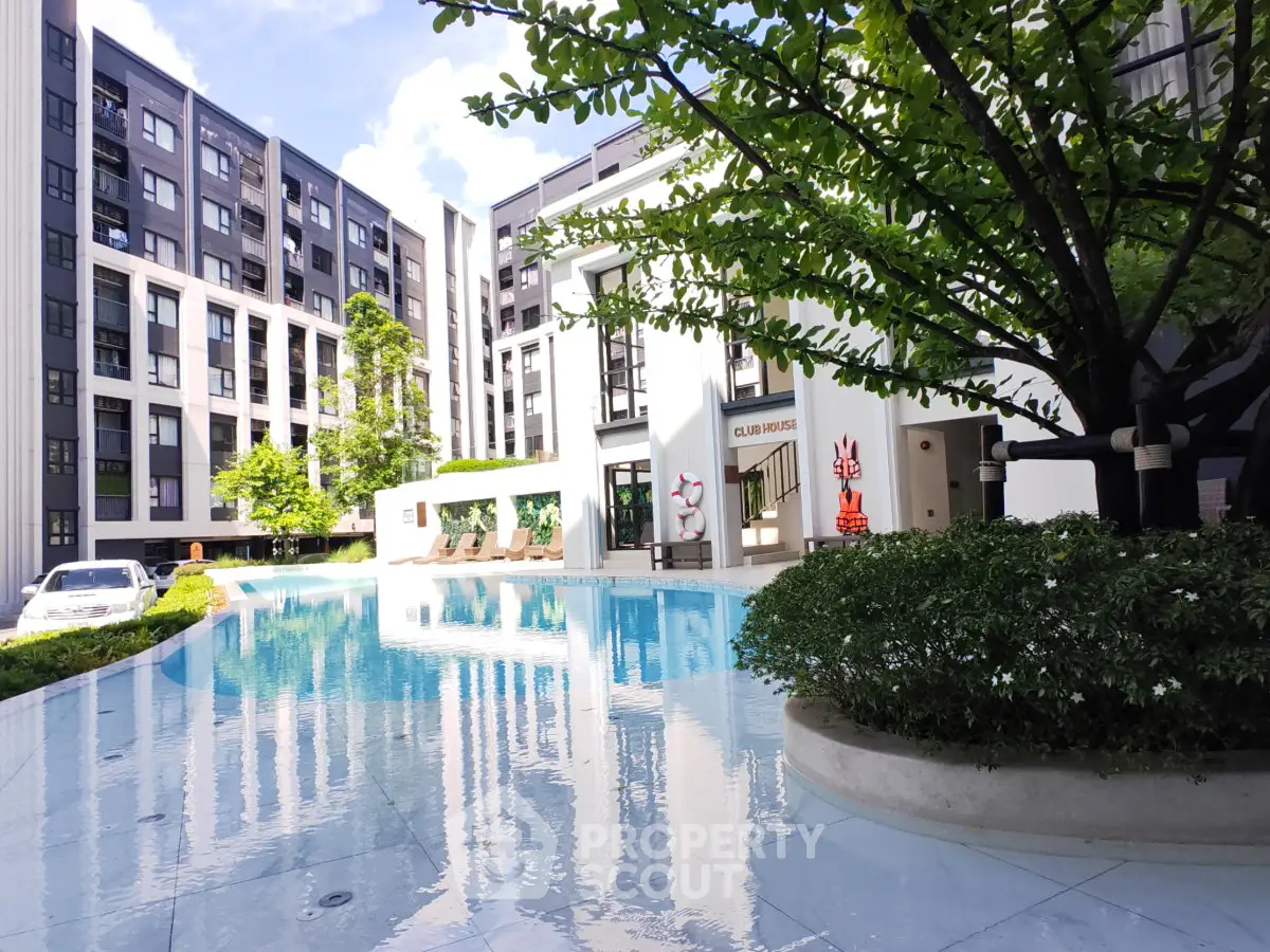 Luxurious modern apartment complex with stunning pool and lush greenery, perfect for relaxation and leisure.