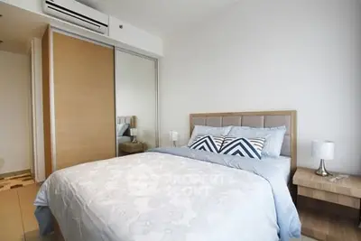 Modern bedroom with stylish decor and mirrored closet doors in a cozy apartment.