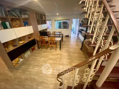 Spacious living room with elegant staircase and built-in shelving, perfect for modern family living.