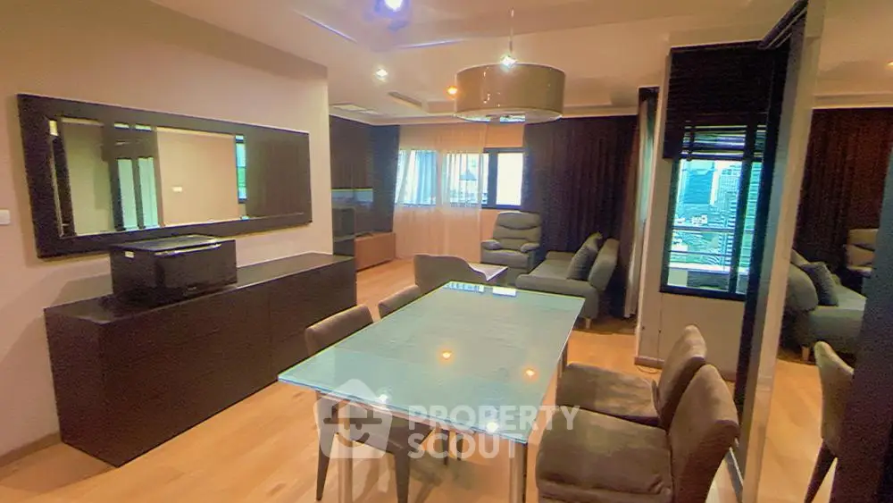 Spacious modern living room with sleek furnishings, large dining table, and flat-screen TV, perfect for entertaining and relaxation.