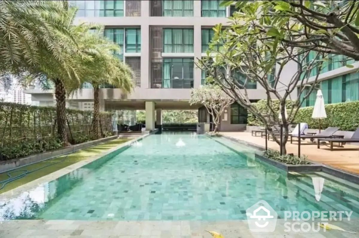 Luxurious residential building with a stunning outdoor pool and lush greenery.