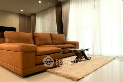 Luxurious living room with plush brown sofa and elegant glass coffee table.