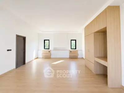 Spacious modern living room with wooden flooring and built-in storage