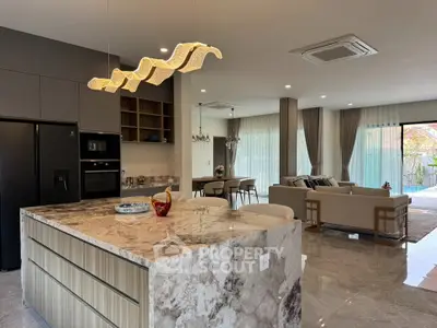 Luxurious open-plan kitchen and living room with marble island and modern lighting