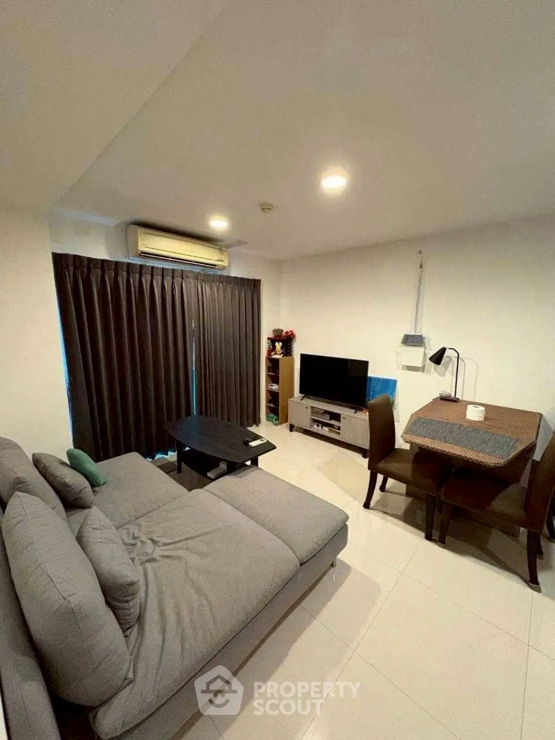 Modern living room with cozy sofa and dining area, featuring sleek design and ample natural light.