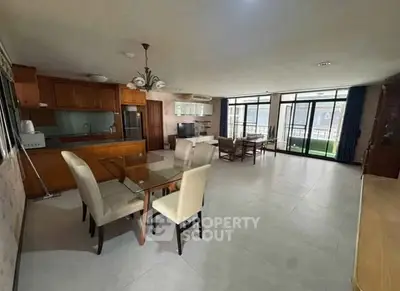 Spacious open-plan living and dining area with modern furnishings and large windows.
