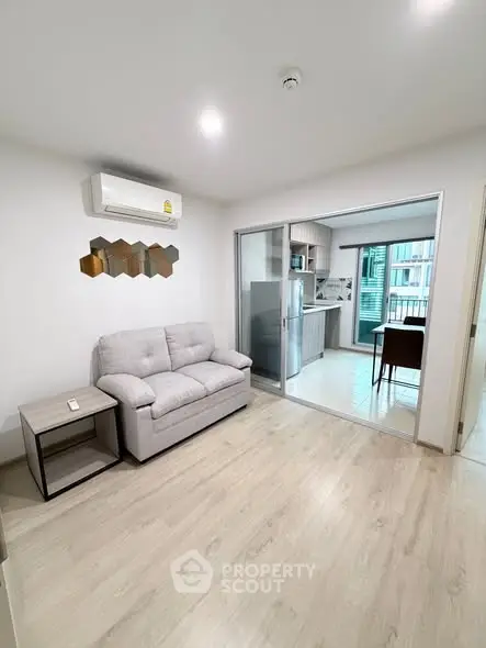 Modern living room with air conditioning and open kitchen layout in a stylish apartment.