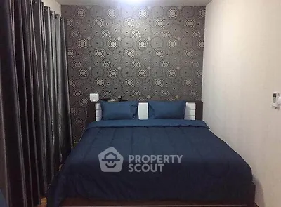 Cozy bedroom with modern wallpaper and elegant bedding in a stylish apartment.