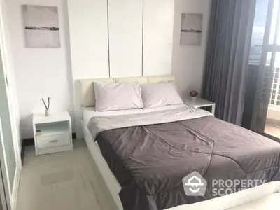 Serene bedroom with a large bed, crisp white walls, ample storage, and natural light streaming in from the balcony, perfect for restful nights.