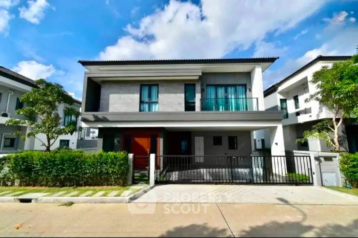 Modern two-story house with sleek design and spacious driveway in a serene neighborhood.