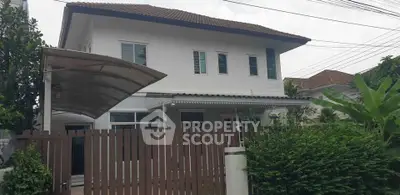 Charming two-story house with a fenced yard and covered carport in a serene neighborhood.