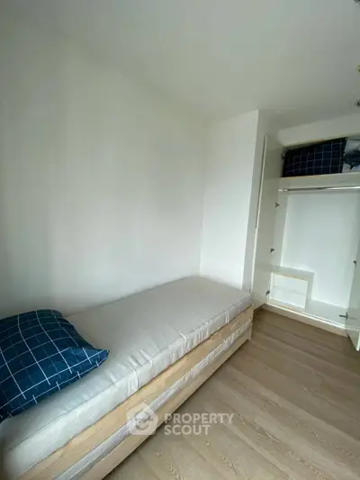 Cozy minimalist bedroom with single bed and built-in wardrobe