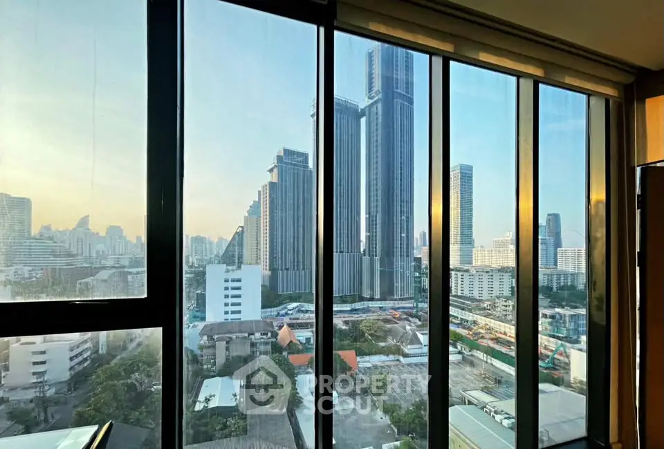 Stunning cityscape view from high-rise apartment window at sunset.