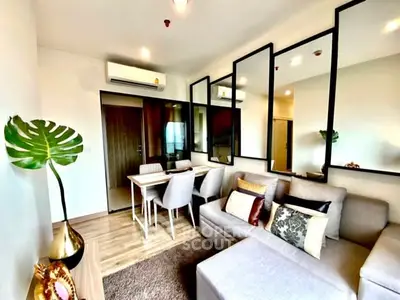 Modern living room with stylish decor and dining area, featuring large mirrors and cozy seating.