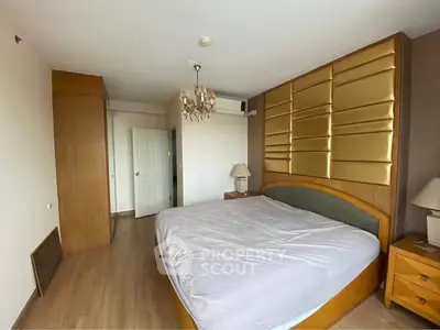 Spacious bedroom with elegant chandelier and modern decor