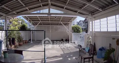 Spacious covered outdoor area with seating and plants, ideal for relaxation or gatherings.