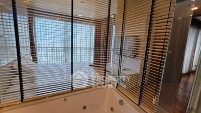 Luxurious bedroom with jacuzzi and modern blinds, offering a serene and elegant ambiance.