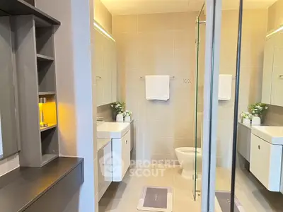 Modern bathroom with sleek fixtures and elegant lighting, featuring a spacious layout and contemporary design.