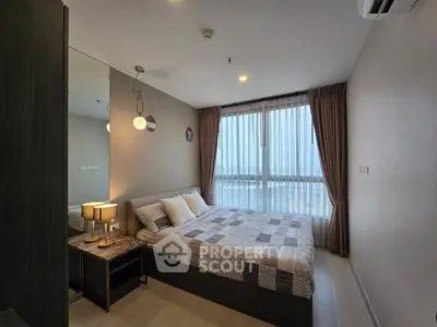 Cozy bedroom with large window and modern decor in a stylish apartment.