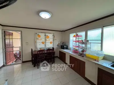 Cozy kitchen with dining area, featuring ample natural light and functional layout for modern living.