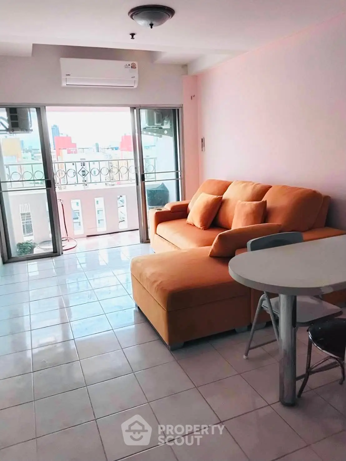 Bright living room with orange sofa and balcony view in modern apartment