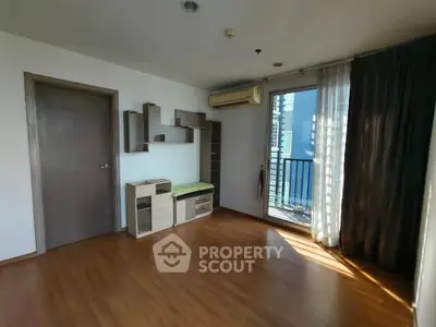 Spacious modern living room with wooden flooring and balcony access
